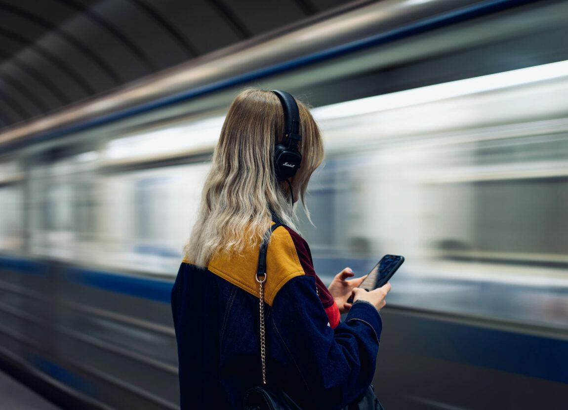 Lady listening to music waiting a subway