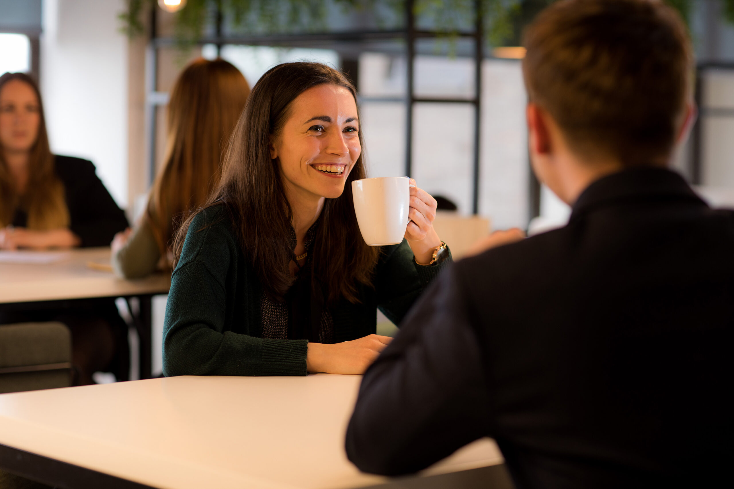 lady drinking coffee at table in meeting